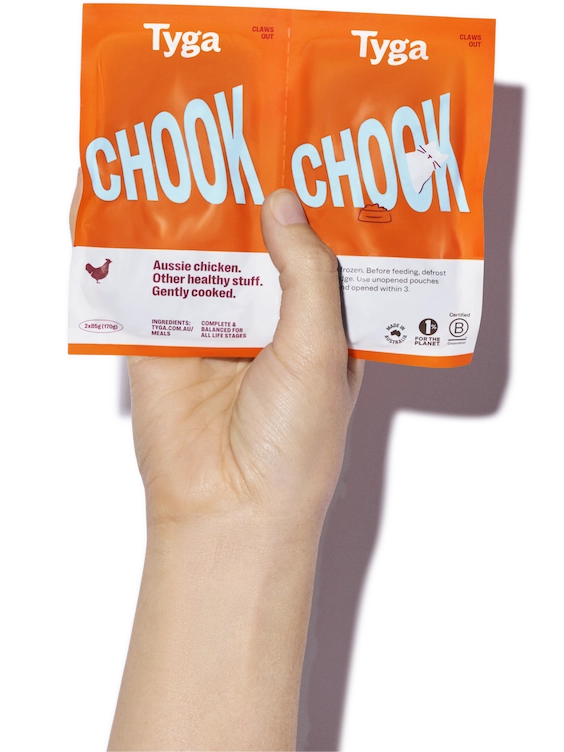 A hand holding a package of Tyga food